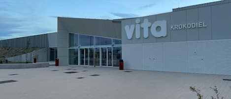 A modern building with the sign "vita KROKODIEL" and a glass entrance.