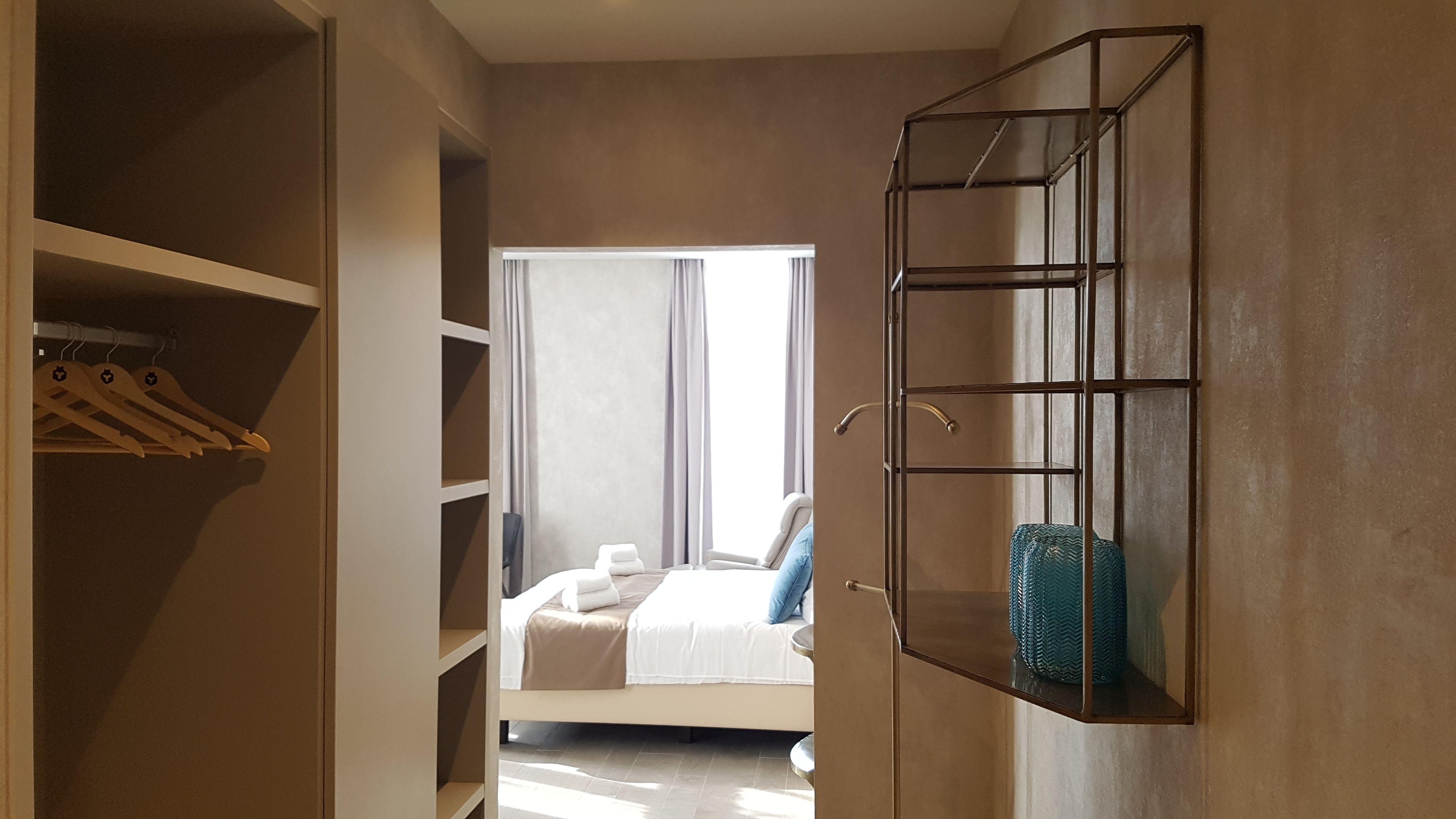 A bedroom with a bed, a wardrobe, and a mirror.