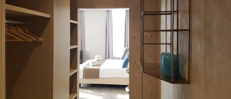 A bedroom with a bed, a wardrobe, and a mirror.