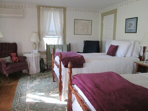 A bedroom with two beds, a chair, a table, and a window with curtains. - Buck's Homestead B&B (Montgomery)
