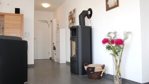A modern kitchen with a black refrigerator, a wooden cabinet, and a vase with flowers. - Leuchtturm 4 (Grossenbrode)