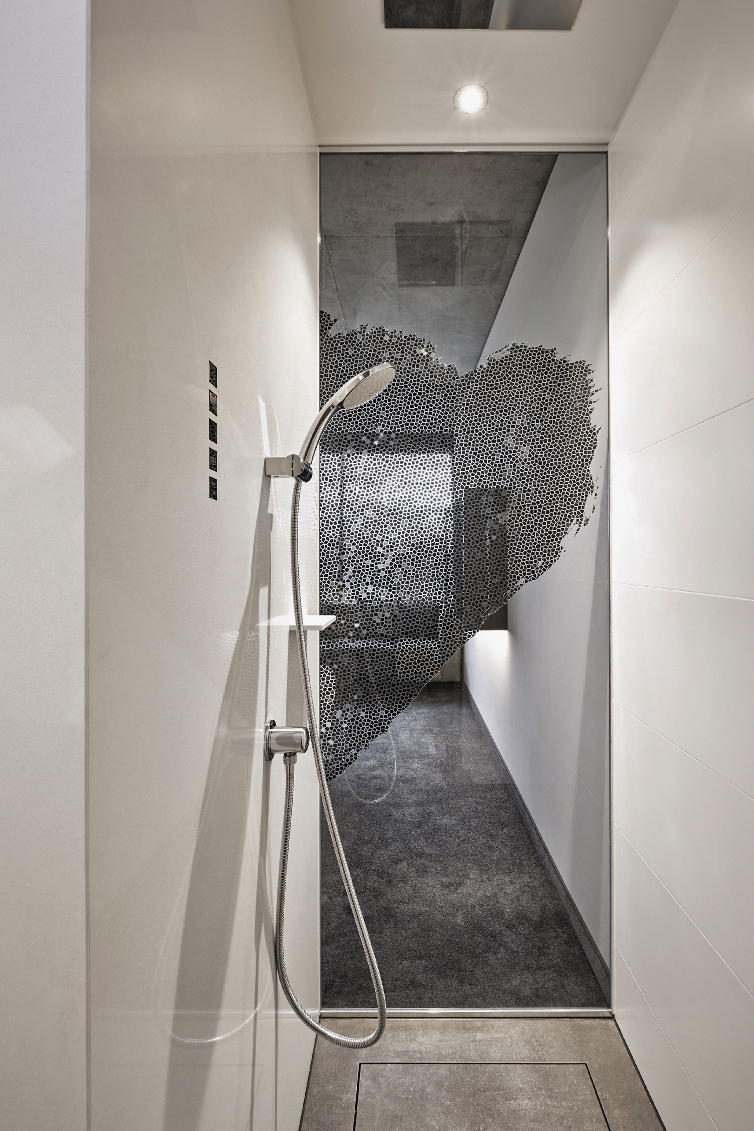 Un área de ducha moderna con un diseño geométrico único en la pared.