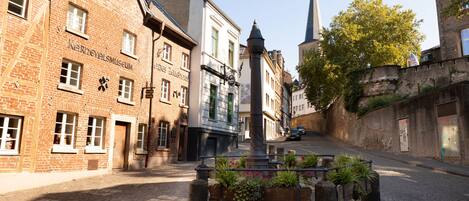 Una calle empedrada con edificios históricos, incluyendo un museo y una iglesia.