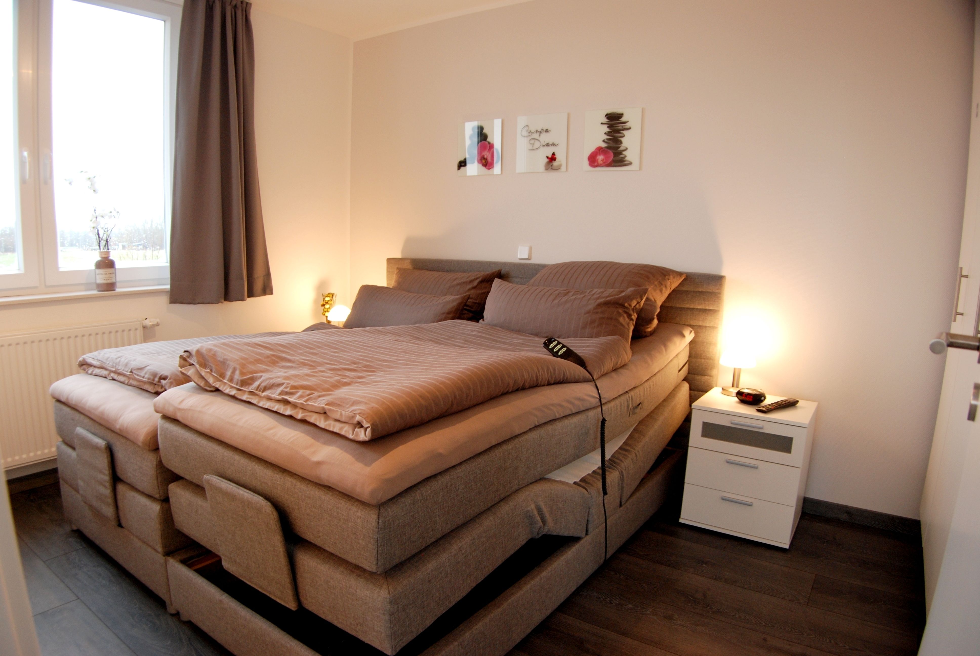 Ein Schlafzimmer mit einem Bett, Nachttischen und einem Fenster mit Vorhängen.