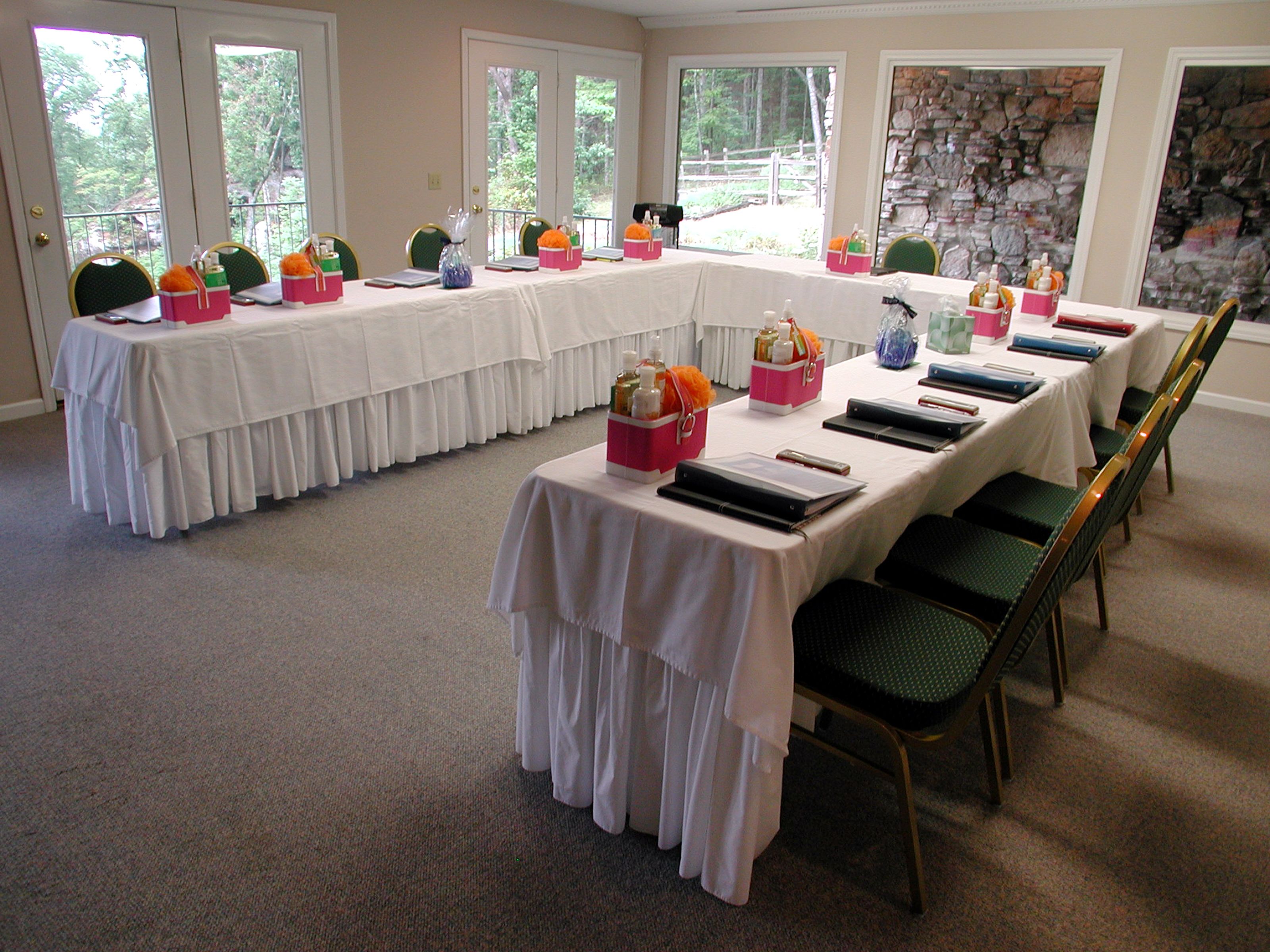 A conference room with a long table, chairs, and various items on the table.