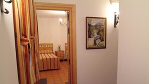 Une chambre à coucher avec un lit, une table de chevet et une affiche accrochée au mur.