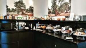 A modern kitchen with a black countertop, various food items, and a coffee machine. - Verdeoliva Bed & Breakfast (Bari)