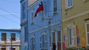 Un edificio con fachada azul, una bandera de Texas y grafitis coloridos.