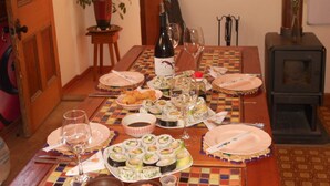 Una mesa de comedor lista con platos, vasos y sushi.