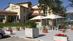 A hotel with outdoor seating and potted plants. - Lieta Sosta (Foligno)