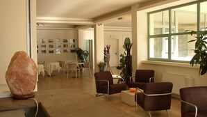 A spacious lobby with a large salt lamp, comfortable seating, a dining area, and a view through a large window. - Lieta Sosta (Foligno)