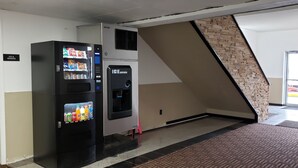 A vending machine area with an ice dispenser and a vending machine offering beverages and snacks. - Travel Inn Of Sidney Ohio (Sidney)