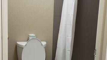 Un baño pequeño con inodoro, cortina de ducha y bañera.
