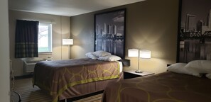 A hotel room with two beds, a window with curtains, a wall-mounted air conditioner, and a large cityscape painting. - Travel Inn Of Sidney Ohio (Sidney)
