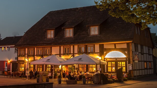 Een klassiek Europees gebouw met een brede centrale ingang, meerdere ramen en terrasjes.
