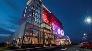 A modern hotel with a prominent 'Encore Hotel' sign, large glass windows, and a well-lit entrance area. - Ramada Encore by Wyndham Aguascalientes (Aguascalientes)