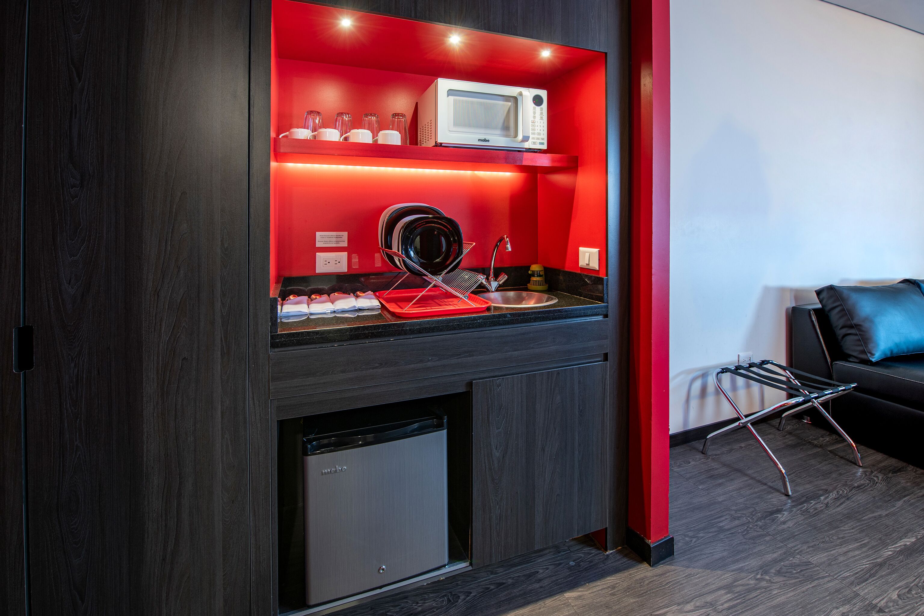 A compact kitchen with a microwave, dish rack, and dishwasher.