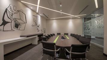 A conference room with a long table, chairs, and a whiteboard.