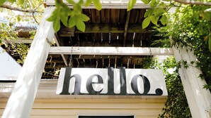 A white building with a 'hello.' sign above the entrance. - Montgomery Inn BnB (Versailles)