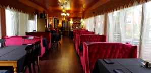 Guests can dine in comfort at the restaurant's central bar, surrounded by cozy booths.