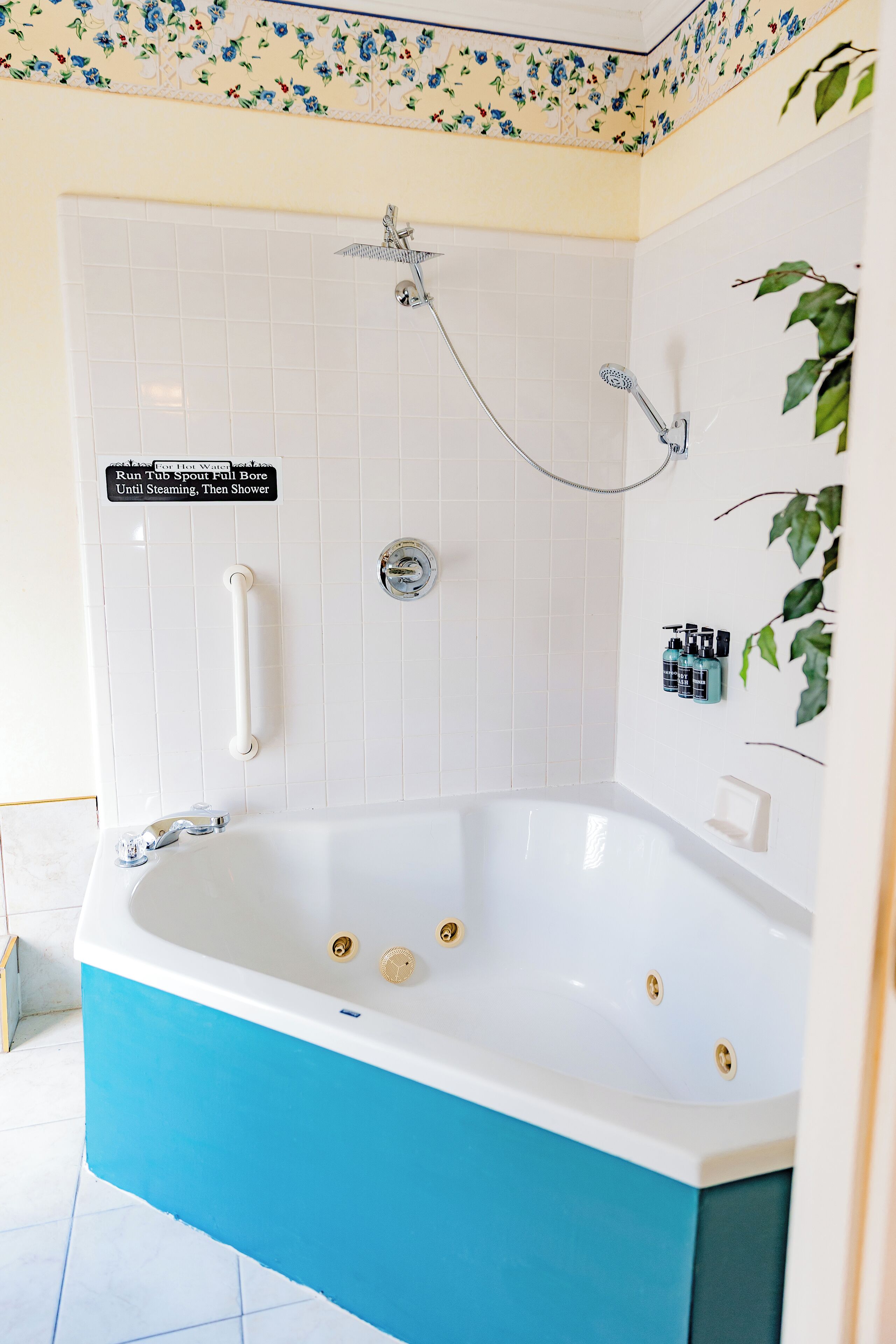 Baño con bañera, ducha y un cartel que indica el uso de la bañera para agua caliente.