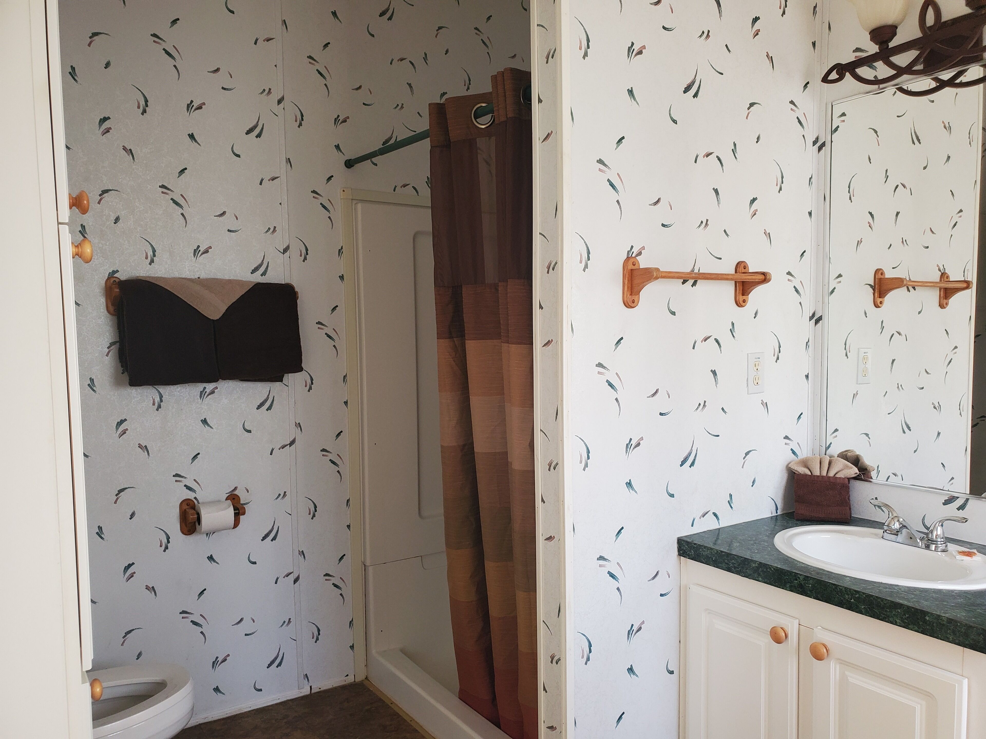 A bathroom with a shower, toilet, and sink.