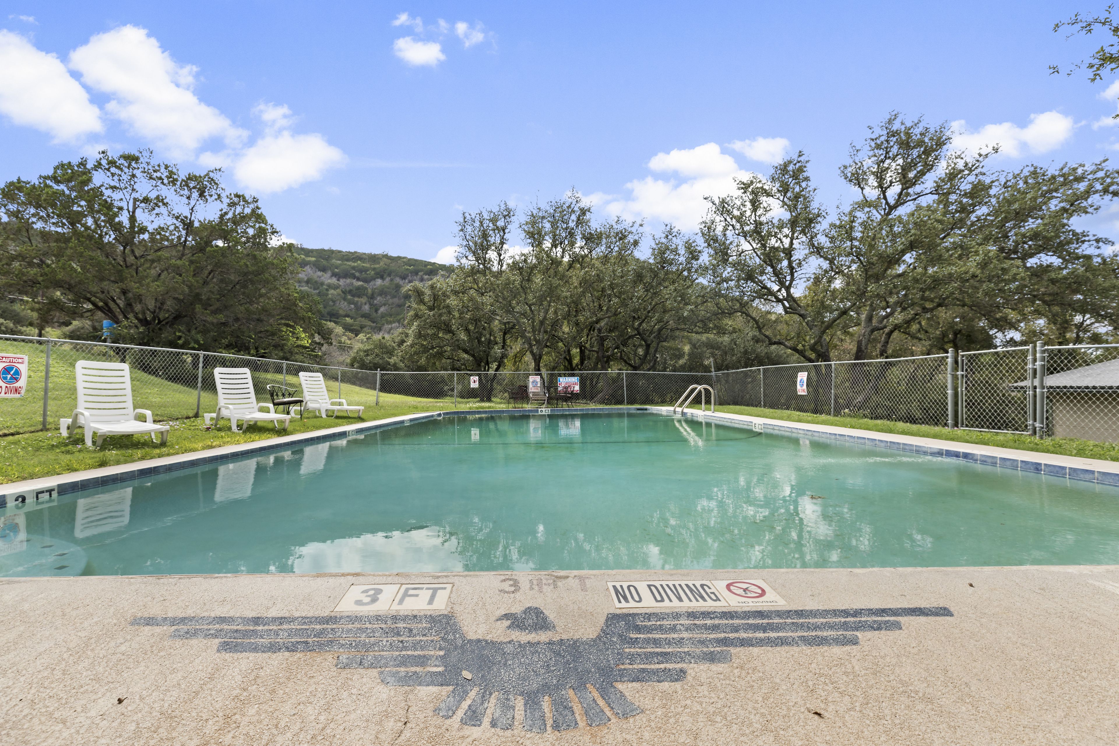Una piscina al aire libre, sillones reclinables de piscina