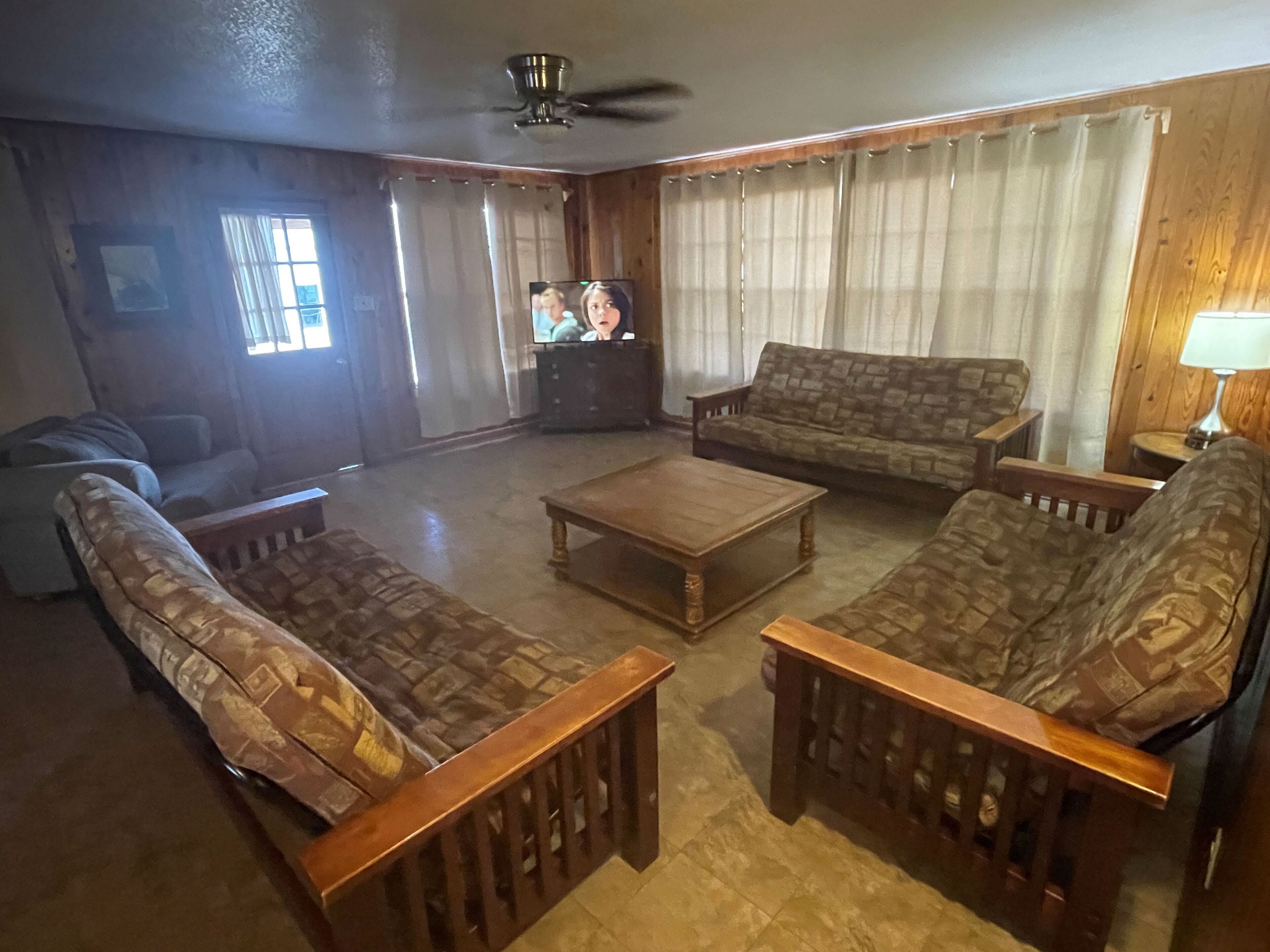 A living room with a sofa set, a coffee table, and a television.