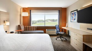 A hotel room with a large bed, a desk, a chair, a TV, and a window with a view of the outdoors. - Holiday Inn Express & Suites Red Wing by IHG (Red Wing)