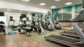 A gym with treadmills, elliptical machines, and weight equipment.