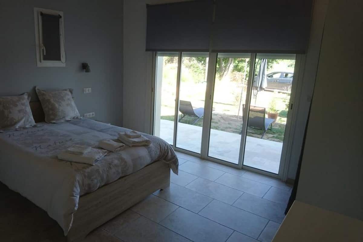 Een slaapkamer met een groot bed, een raam en uitzicht op de omgeving.