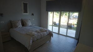 A bedroom with a large bed, a window, and a view of the outdoors.