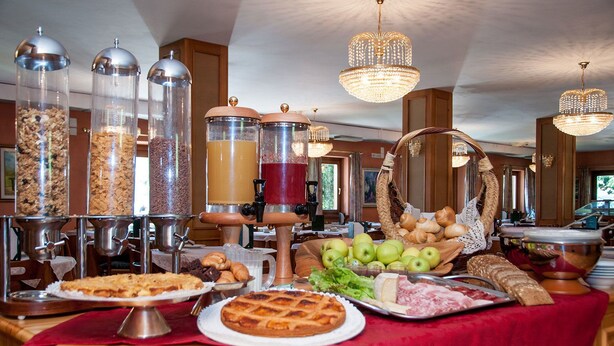 Un bufé con una variedad de alimentos, entre ellos frutas, pastelería y bebidas.
