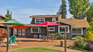 A house with a patio area featuring outdoor furniture and umbrellas. - Brookside Bed & Breakfast (Hood River)