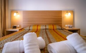 Ein Hotelzimmer mit einem Bett, zwei Nachttischen und zwei Wandleuchten.