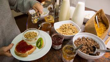 A breakfast setting with various food items and condiments on a table.