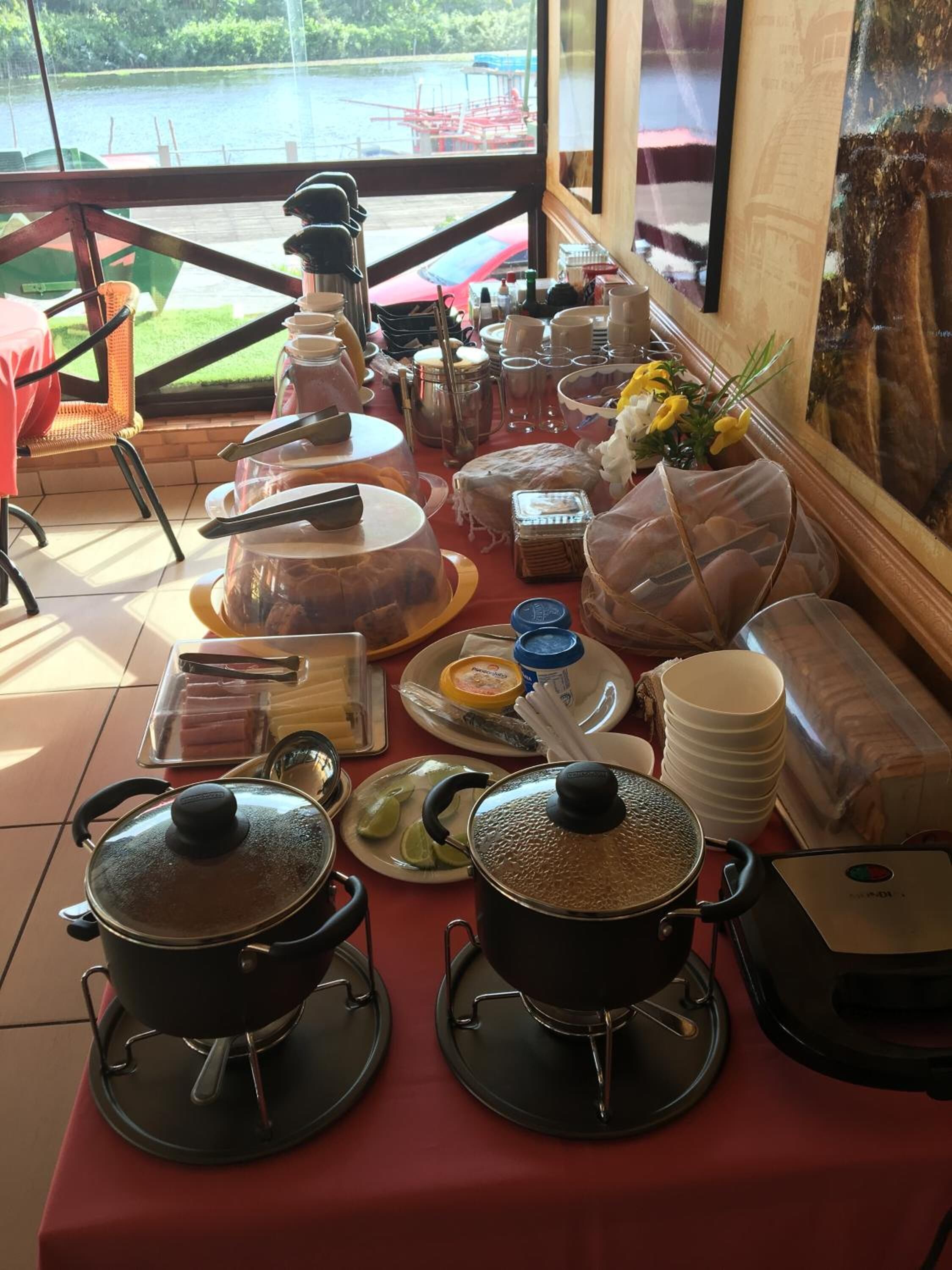 A breakfast buffet setup with various food items and cooking equipment.