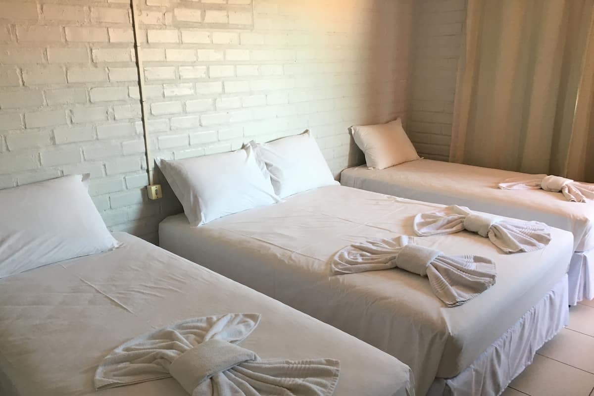 Ein Hotelzimmer mit zwei Betten, jeweils mit einem ordentlich gefalteten Handtuch.