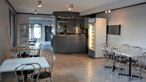 A modern restaurant with a bar area, dining tables, and chairs. - Motel Quatre Saisons (Forestville)