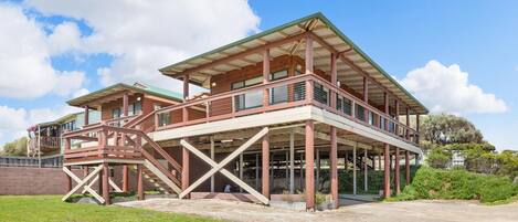 A two-story building with a balcony and a covered outdoor area.