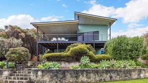 A two-story house with a balcony, stone steps, and various plants. - Beachside at Margaret River (Prevelly) - Modern beach house, ocean views, spacious interior, reverse (PREVELLY)