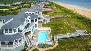 Una propiedad costera con una casa grande, piscina y vista al mar.