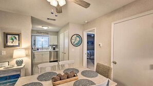 A dining area with a table set for four, surrounded by chairs. There is a kitchen in the background with cabinets and a countertop. - Half-Mi to Beach: Hilton Head Condo w/ Lagoon View (Hilton Head)