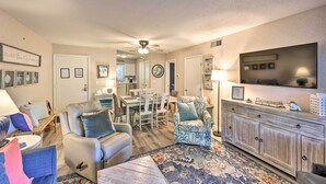 A living room with a sofa, armchair, and a dining area with chairs and a table. - Half-Mi to Beach: Hilton Head Condo w/ Lagoon View (Hilton Head)