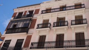 A multi-story building with balconies, windows with shutters, and a clear blue sky in the background. - Modern Madrid Downtown Puerta Del Sol M (PRE2B) (Madrid)