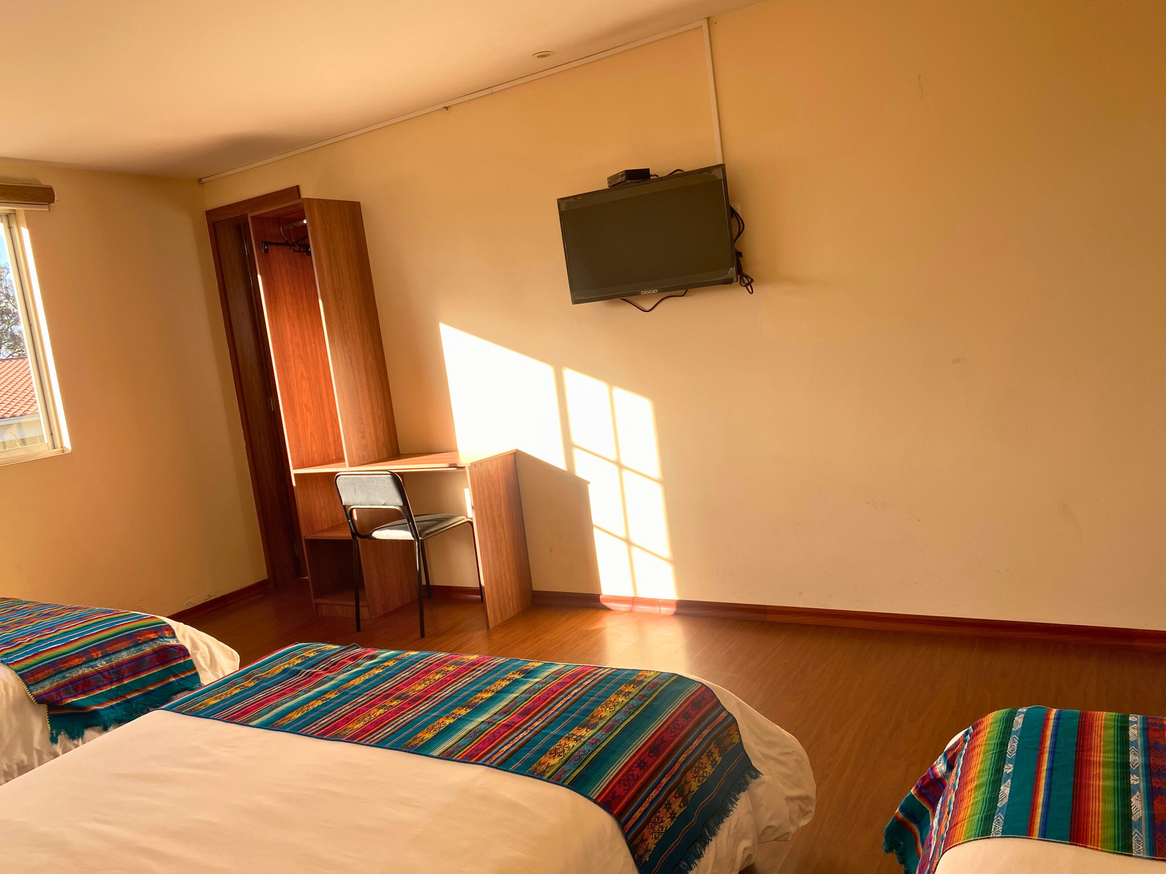 Une chambre avec deux lits, un bureau et une chaise.