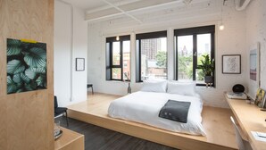 Een moderne slaapkamer met een videbed, grote ramen en uitzicht op de stad.