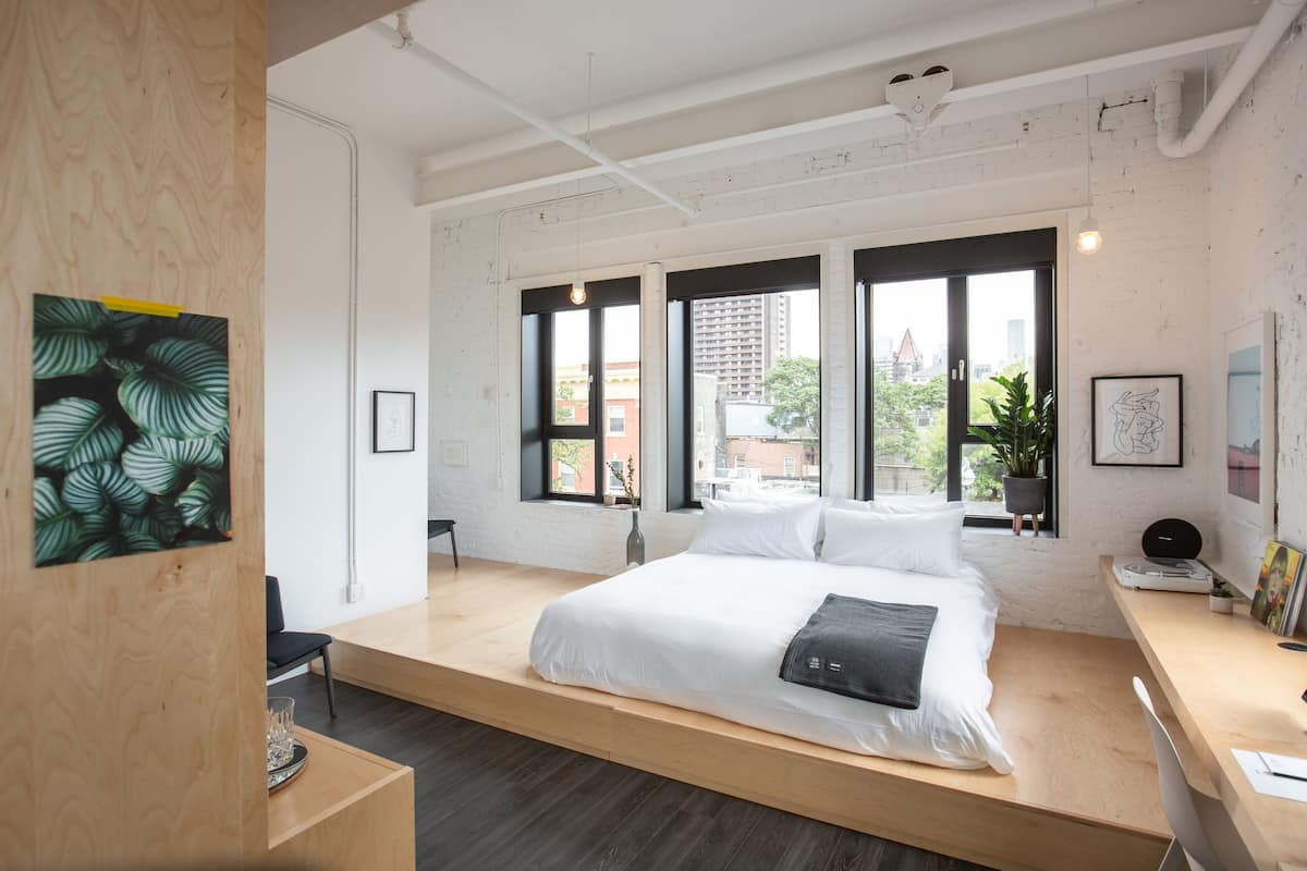 Een moderne slaapkamer met een videbed, grote ramen en uitzicht op de stad.