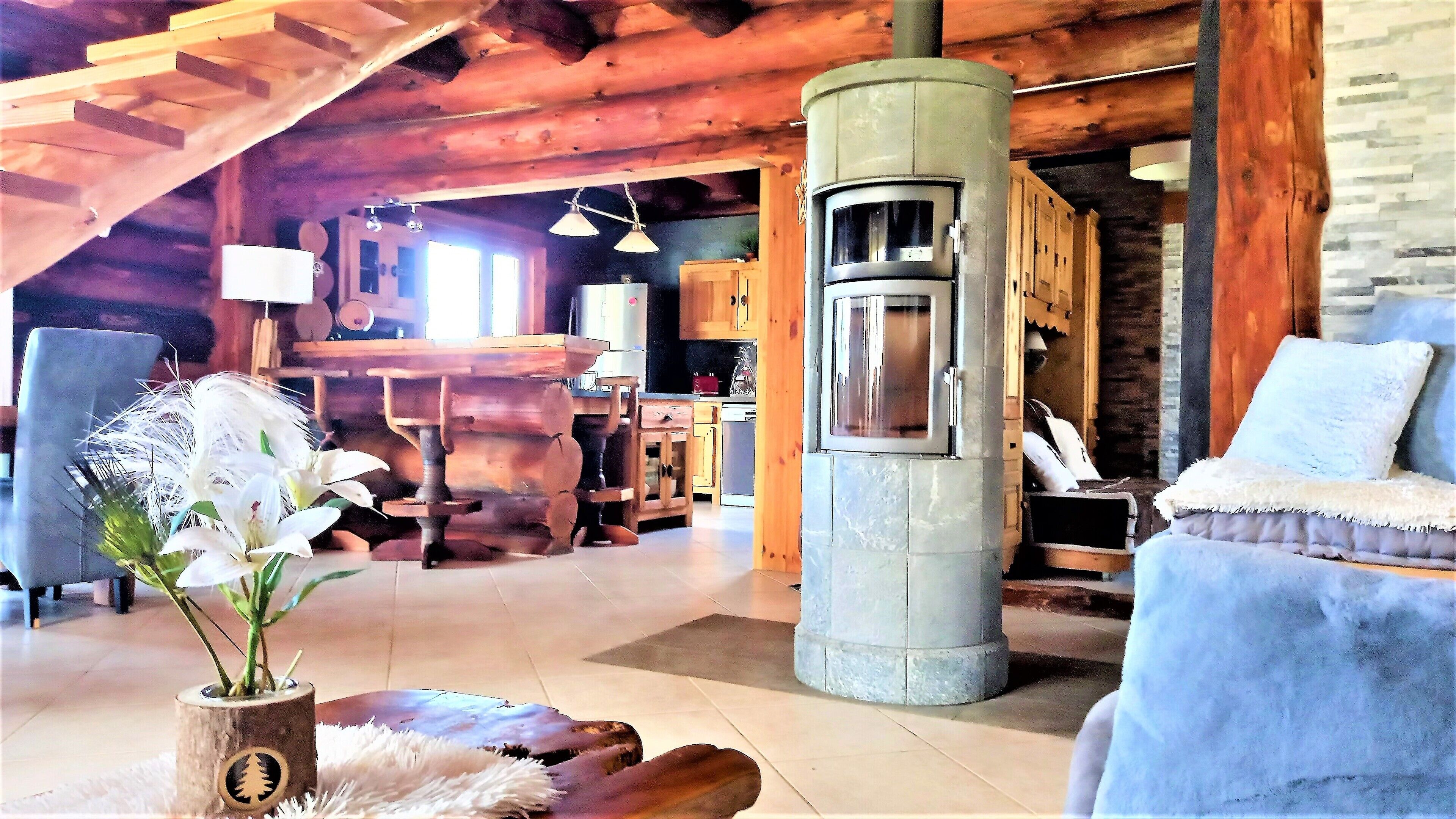 A rustic interior with a stone fireplace, wooden furniture, and a cozy seating area.