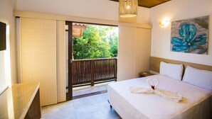 Una habitación de hotel con cama, techo de madera, un cuadro y vistas a zonas verdes.